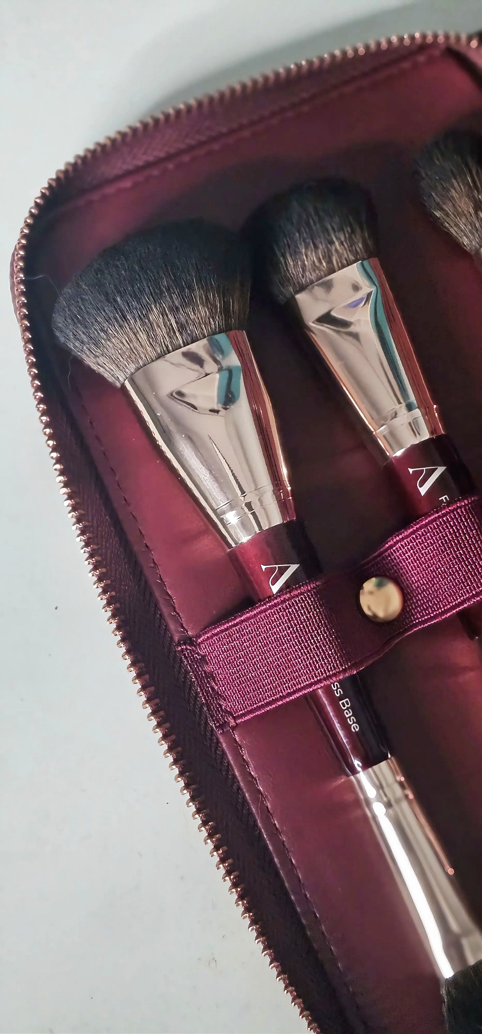 Makeup brushes in a red case on a light gray background